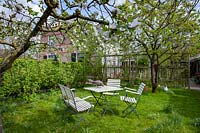 Seating area in the country garden under apple tree, Malus domestica Notarisappel 