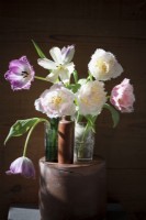 Mix of fringed tulips in small vases on display. Sunbeam shining on the bouquet of flowers. Locally grown