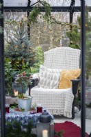 Cushions and blanket on recycled plastic chair inside greenhouse