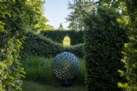 'Mantle' an artwork by David Harber set amongst clipped hedges