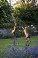 'Boxing Hares' statue by Miranda Michels with Nepeta racemosa 'Walker's Low'