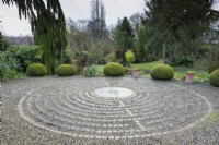 Pavement Maze at York Gate Garden in February surrounded by strongly shaped evergreens including clipped yews.