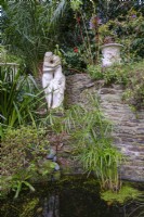 Statue of embracing couple with quiet pond and Papyrus water plants