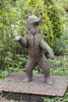 Figure of bear standing in the The Glade. April. Spring.