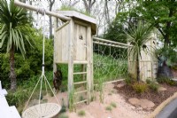 Wooden climbing frame and rope swing and  spider web. May