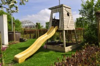 Mobile children's play feature with slide in a spring garden.